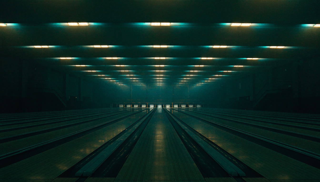 Salón de boliche con muchas pistas y luces doradas y turquesa