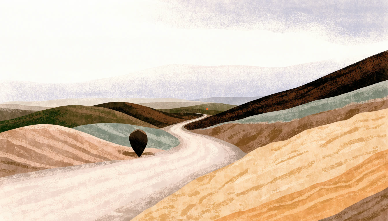 Camino de terracería entre lomas al atardecer con una piedra en forma de marcador