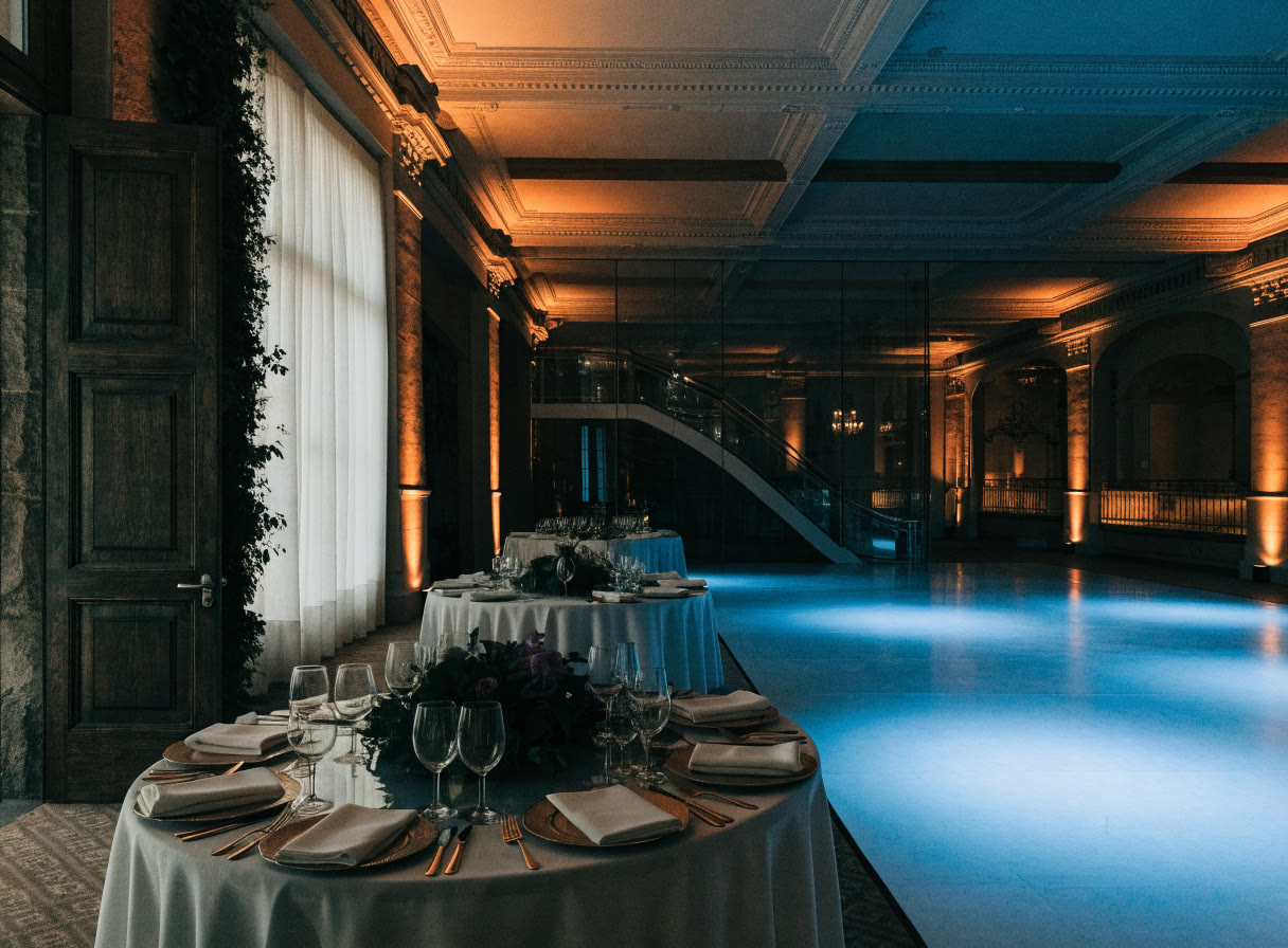 Salón de bodas con muros iluminados en ámbar y pista con luz azul