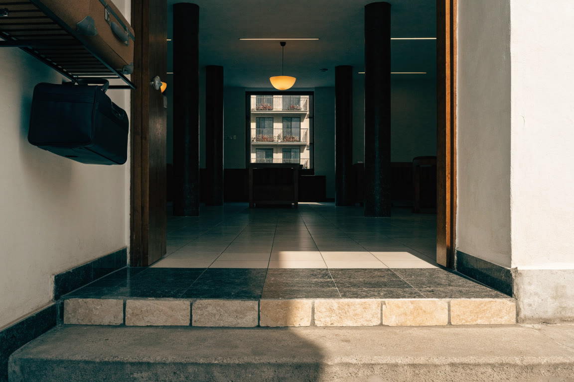 Entrada de hostal con umbral limpio y lámpara cálida