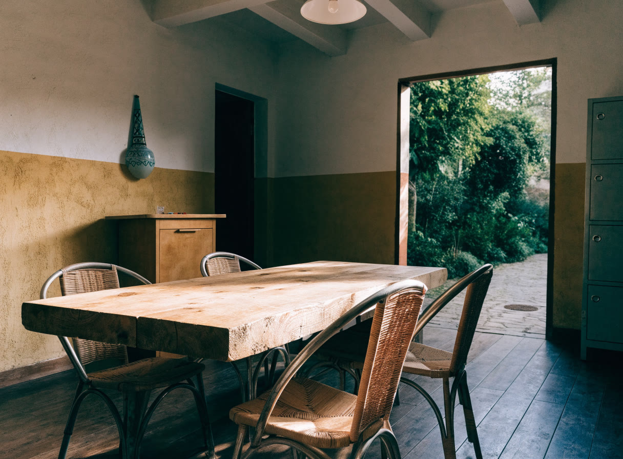 Sala común ordenada con mesa y luz de patio