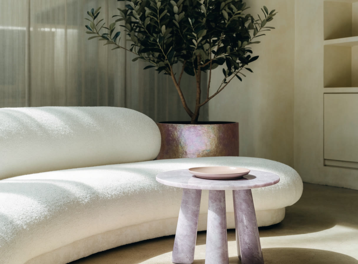 Sala de espera con sofá curvo y una planta grande
