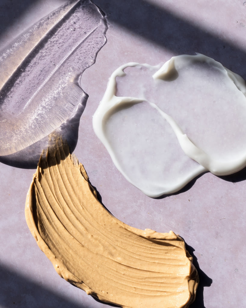 Muestras de gel, esencia y crema sobre cerámica lila