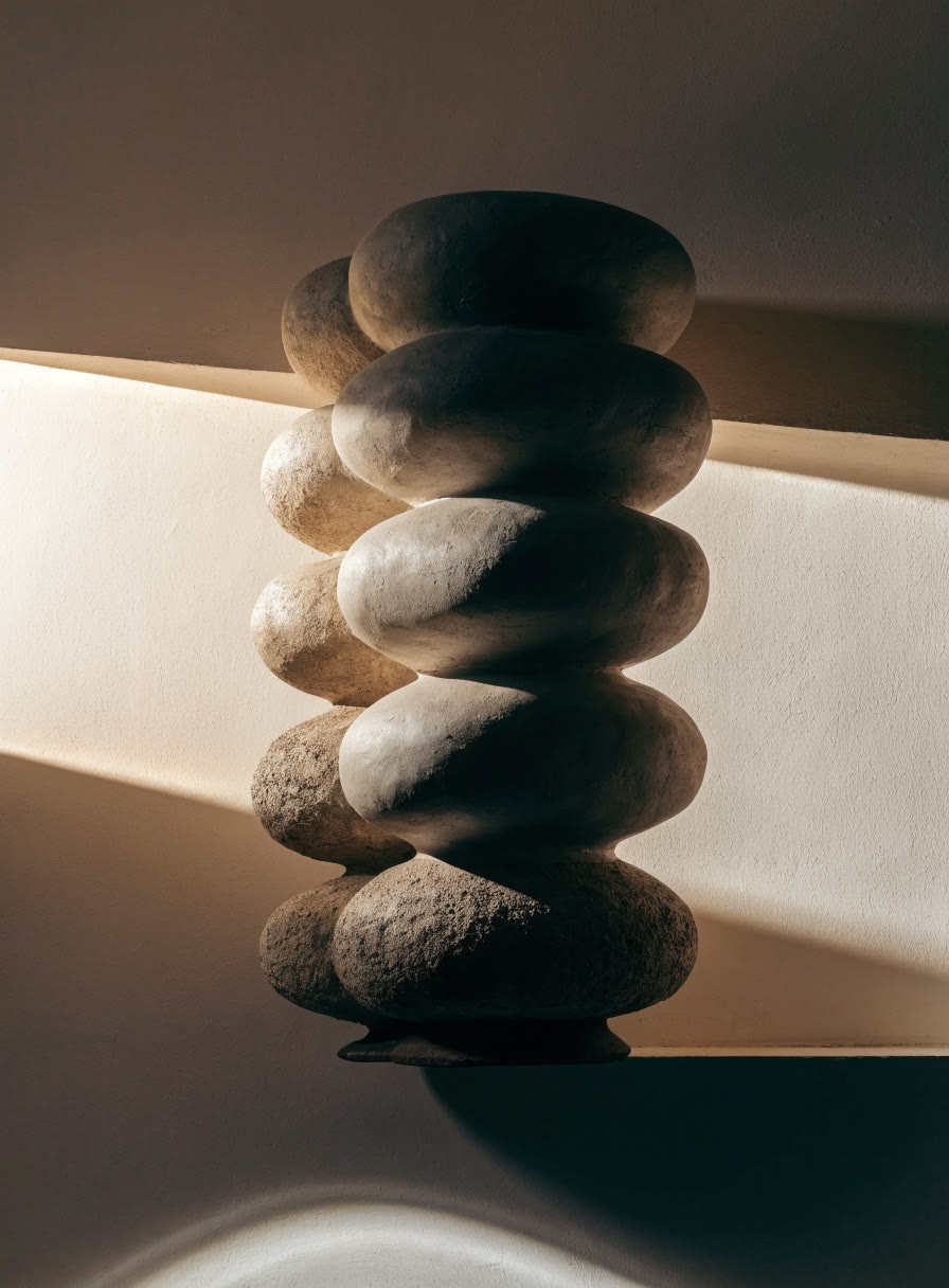 Escultura de gres de formas apiladas entre franjas de luz y sombra